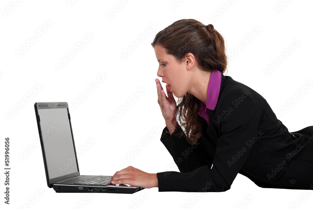 Woman yawning in front of a computer Woman yawning in front of a computer