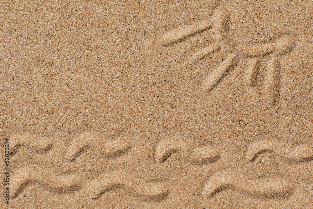 Drawing sun and waves on the sand