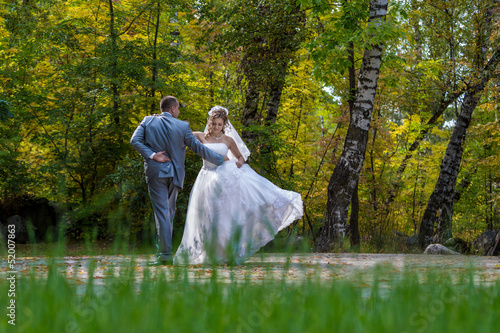 Newly married couple dancing in field. Outdoor portrait of bride