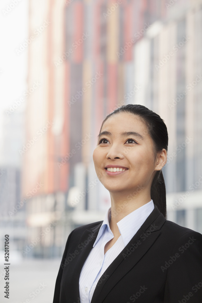 Portrait of smiling young businesswoman, looking up Portrait of smiling young businesswoman, looking up