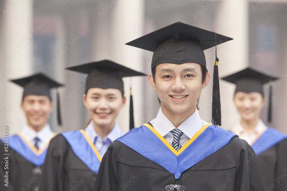 Four University Graduates Smiling, Looking at Camera Four University Graduates Smiling, Looking at Camera