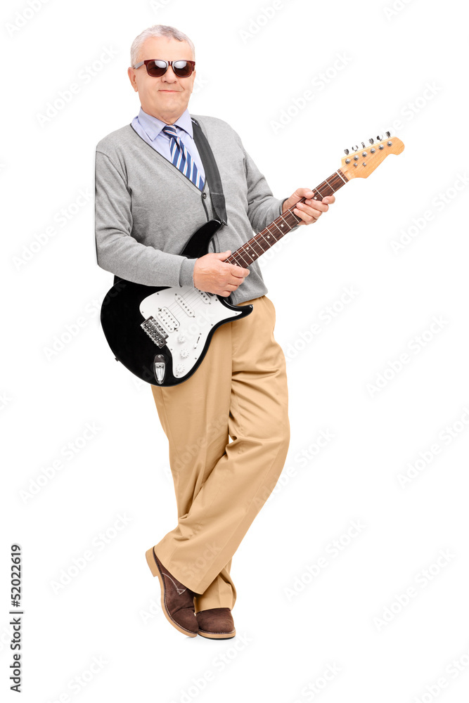 Full length portrait of a mature man with electric guitar leanin Full length portrait of a mature man with electric guitar leanin