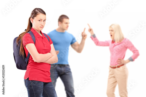 Deppressed teenager looking at camera with mother and father arg