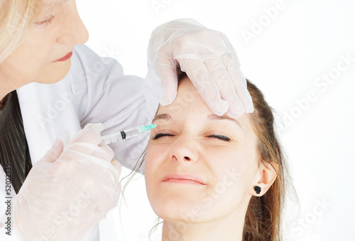 Young woman getting botox in her frown photo