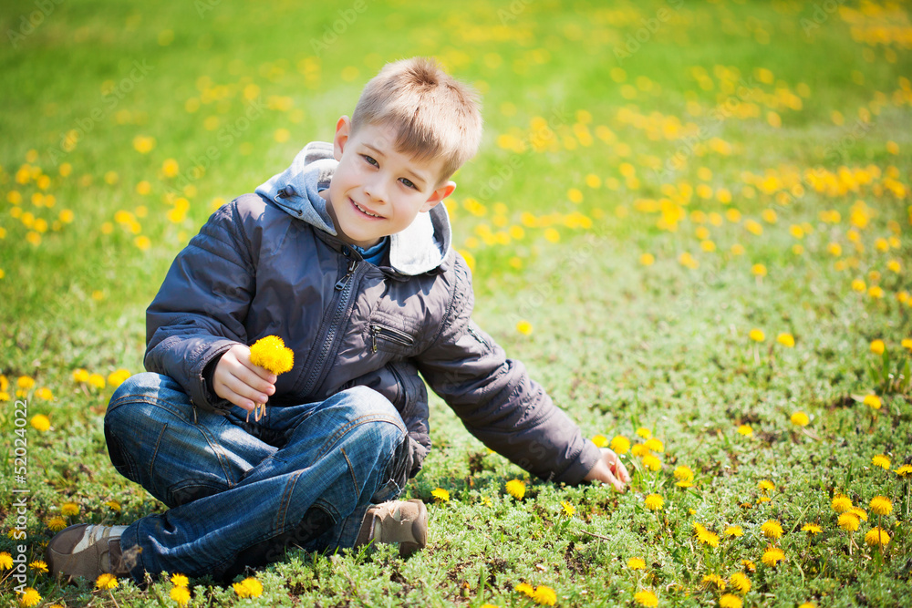 boy with dandelions in a green park. summer boy with dandelions in a green park. summer