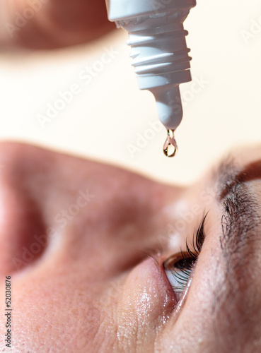 Man applying eyedrops photo