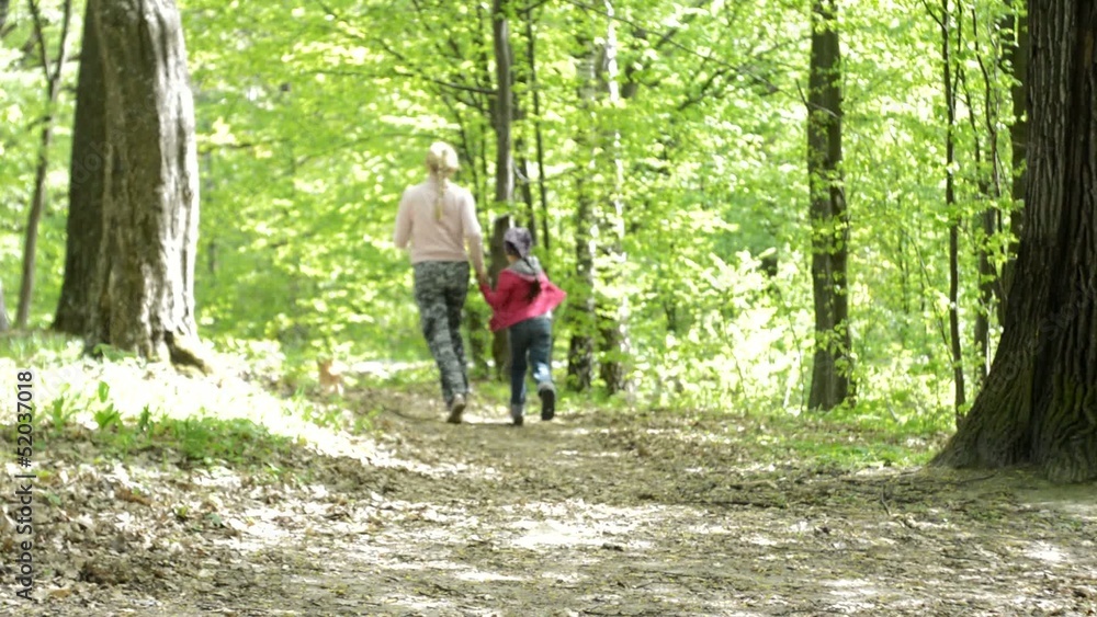 Mom with her daughter and a dog run in the park Mom with her daughter and a dog run in the park
