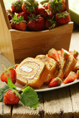 Photos roulade cake with cream and strawberries