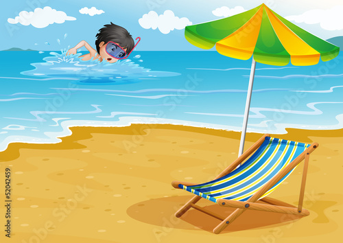 A boy swimming at the beach with an umbrella and a foldable bed