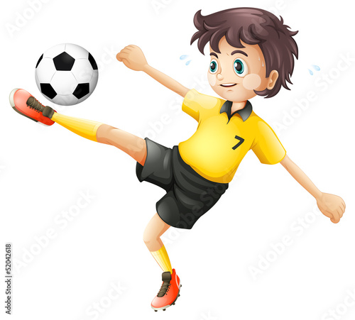 A boy kicking the soccer ball