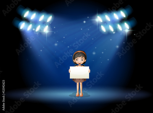 A girl holding an empty signage at the stage with spotlights