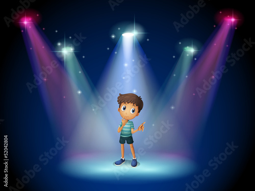 A boy acting at the stage with spotlights