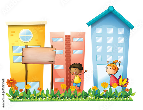 A girl and a boy in the garden with a wooden signboard