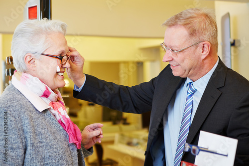 Woman buying glasses at optician photo