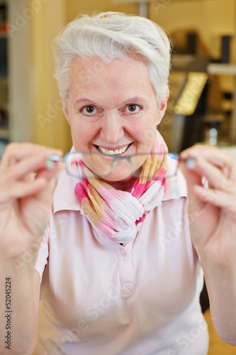 Optician with glasses in her hand photo