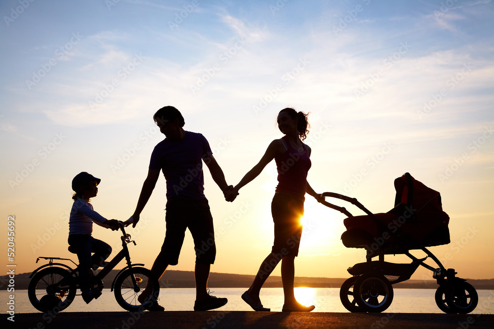 happy family walking on sunset