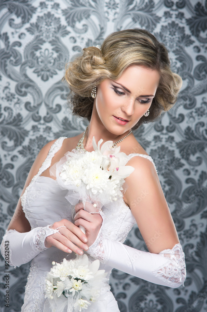 A young blond bride posing in a white dress