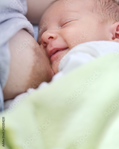Obraz na płótnie Newborn baby sucks mother's breast. w salonie