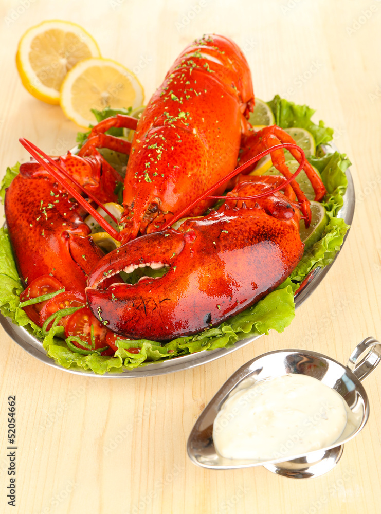 Red lobster on platter with vegetables on wooden table close-up Red lobster on platter with vegetables on wooden table close-up