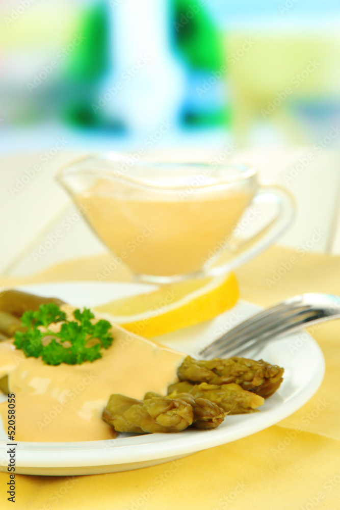 Asparagus on plate, on wooden table on bright background Asparagus on plate, on wooden table on bright background