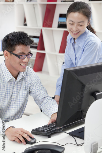 Happy coworkers working on their computer in the office