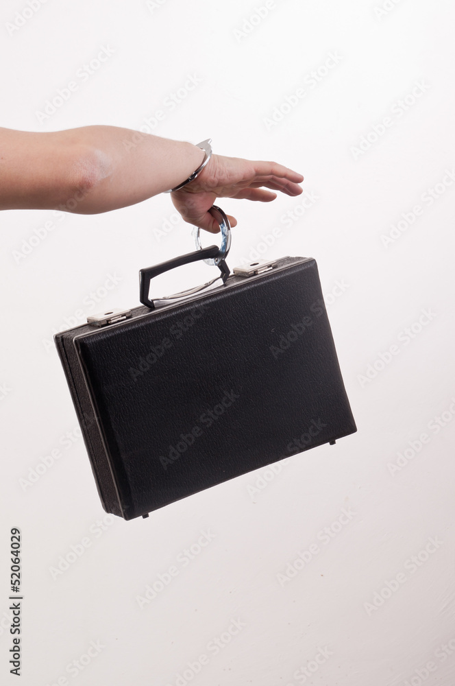 Obraz premium females hand with handcuff and a suitcase
