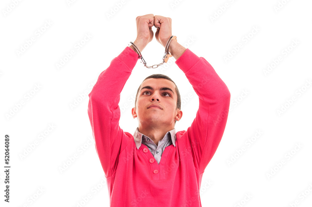 Fototapeta premium man in handcuffs, looking at his hands with regret and remorse