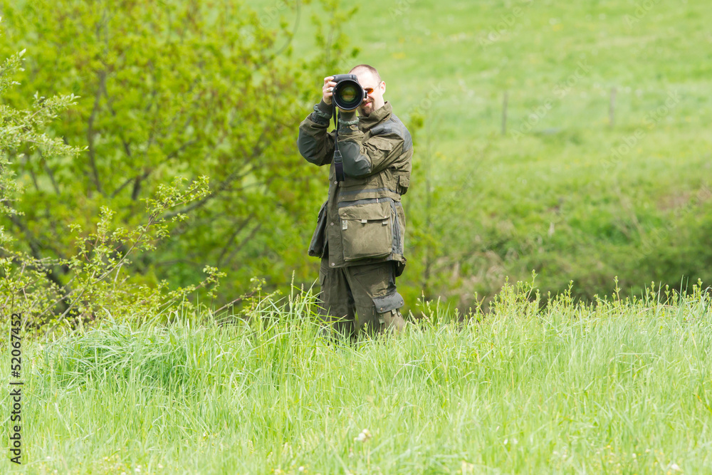 Wildlife photographer with long telephoto Wildlife photographer with long telephoto