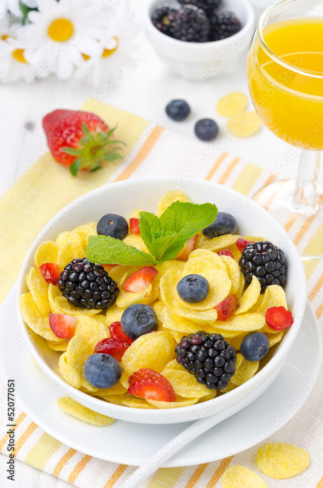 Cornflakes, fresh berries, orange juice for breakfast vertical Cornflakes, fresh berries, orange juice for breakfast vertical