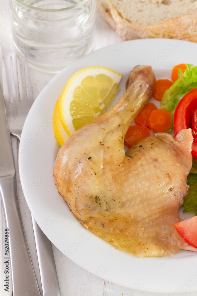 chicken with salad and lemon on white plate chicken with salad and lemon on white plate
