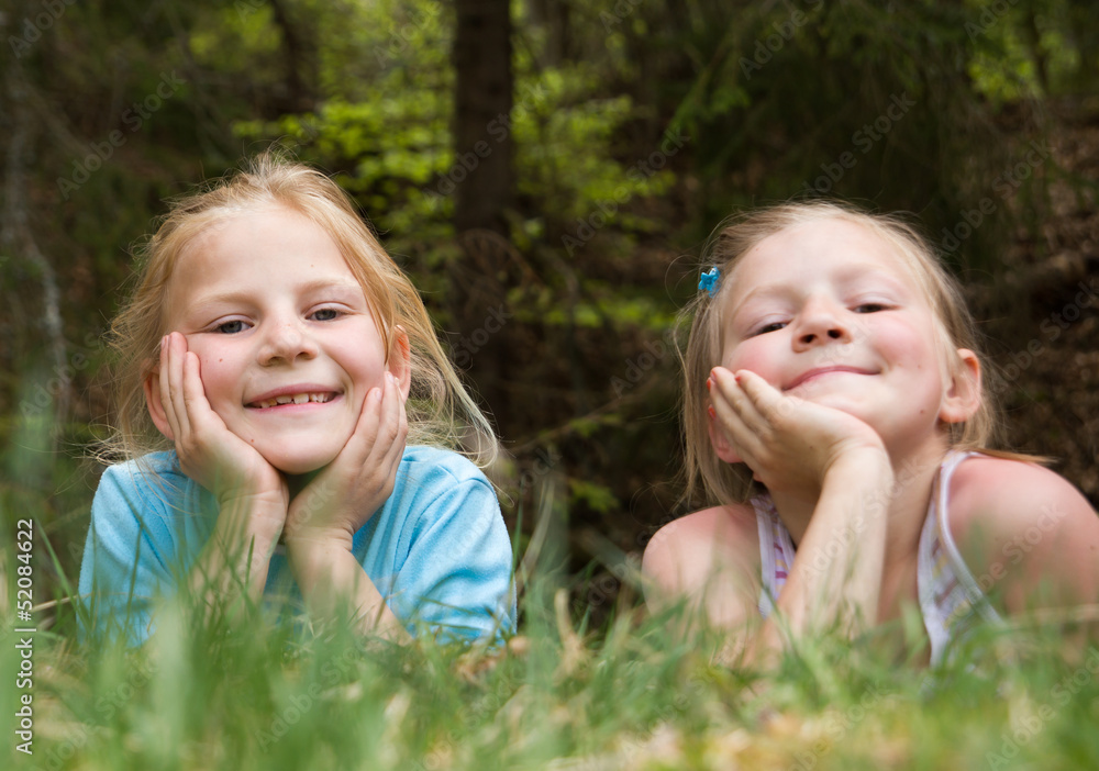 Two sisters lying outdoors in the forest Two sisters lying outdoors in the forest