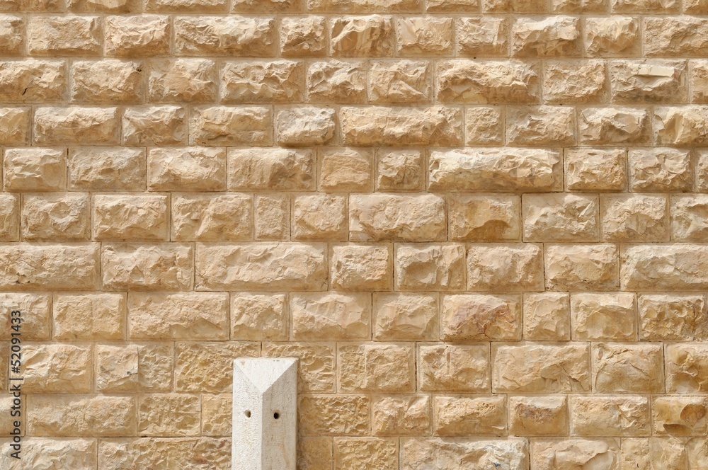 Obraz premium Texture of the wall built of rough yellow stone blocks