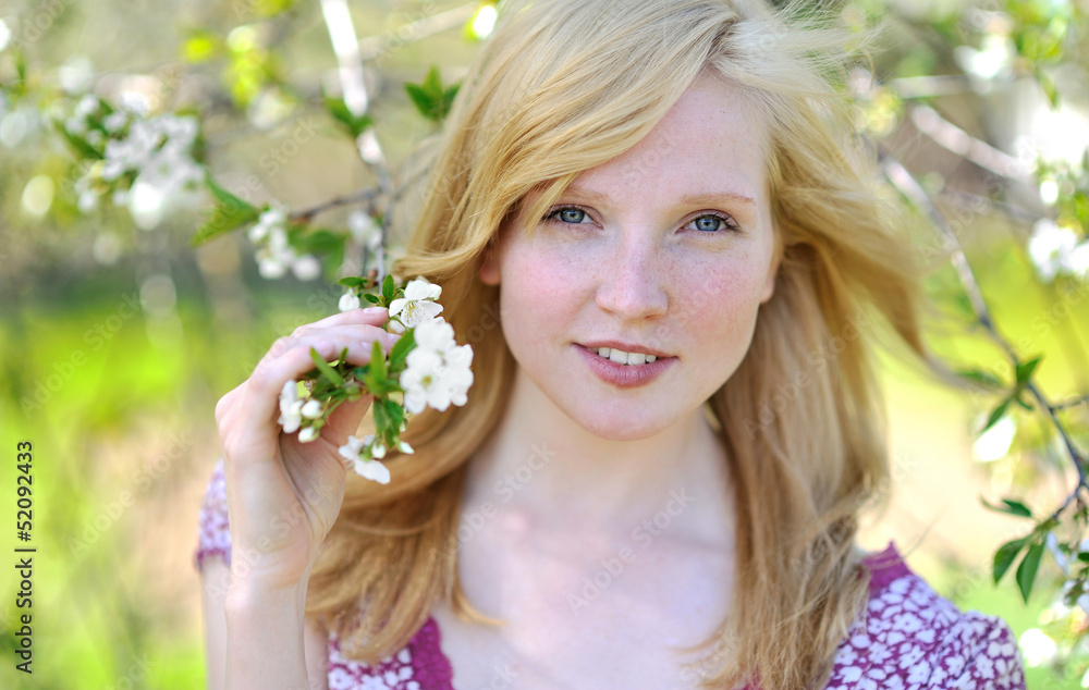 Fototapeta premium Beautiful girl in blooming tree - spring sunny portrait