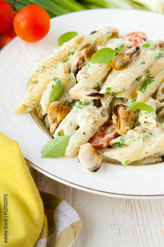 penne pasta with mussels and cream on a plate