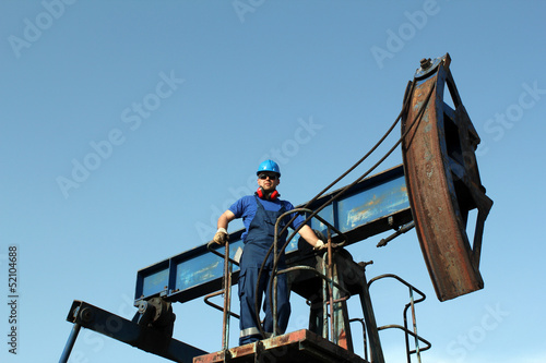 oil worker standing on pump jack