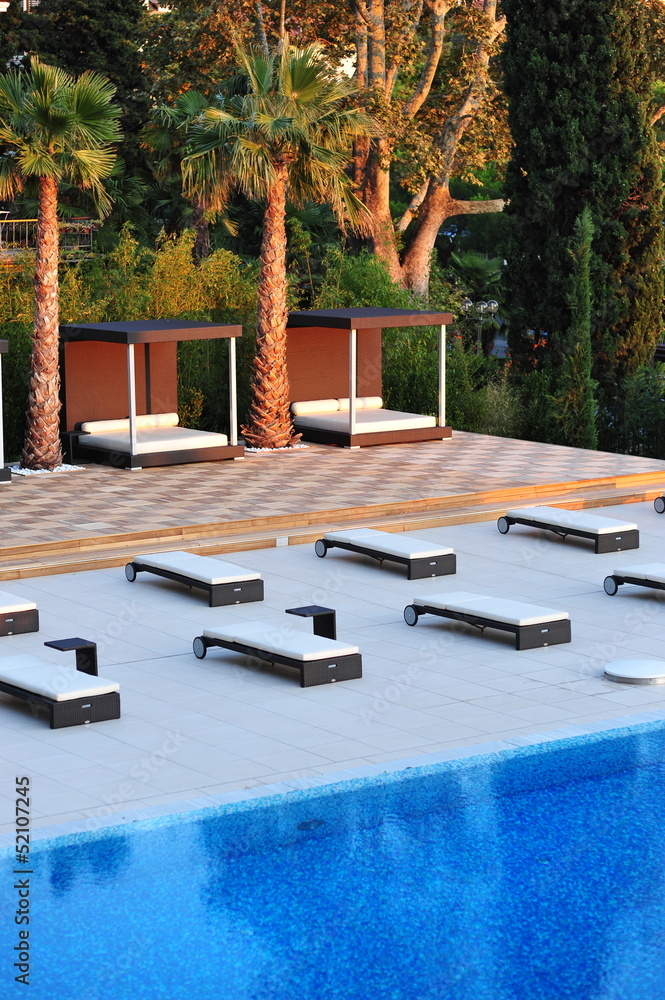 Pool area with Lounge chairs Sun decks by the swimming pool Stock