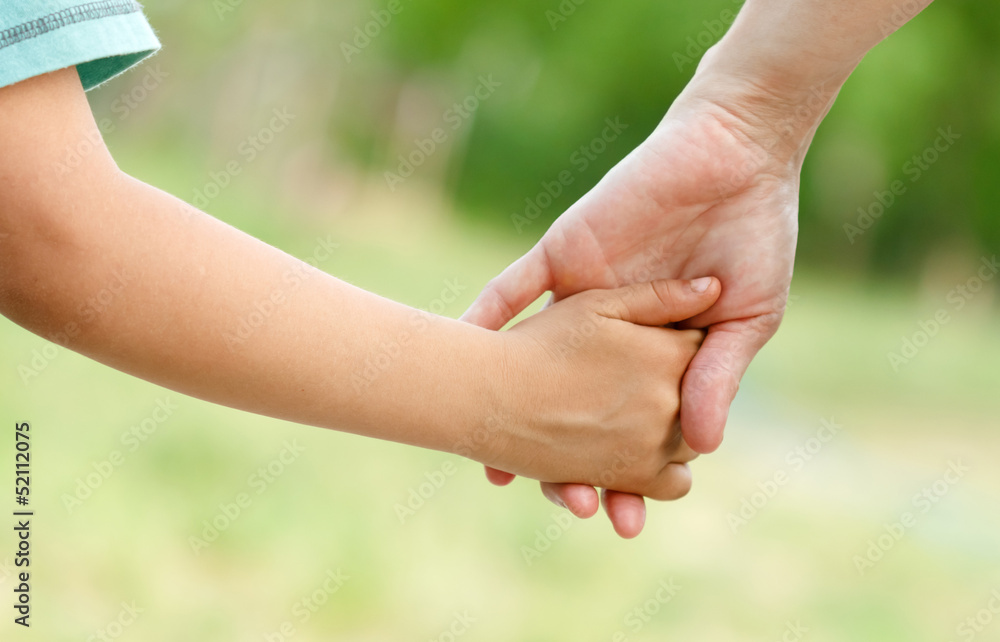 Mother holds the hand of her child