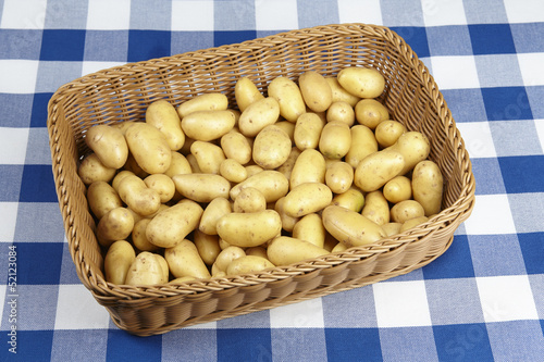 Korb mit mit Drillingen (Kartoffeln) auf karierter Tischdecke photo