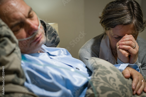 Photography Old wife praying for terminally ill husband