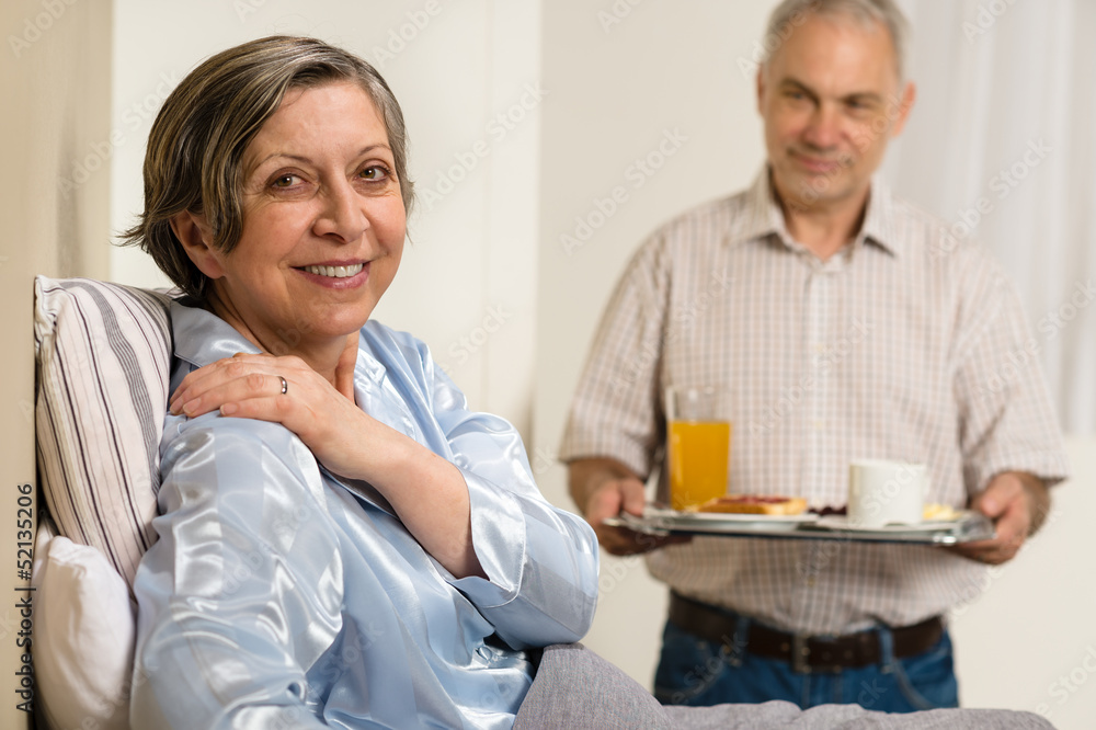 Caring senior man bringing breakfast to wife Caring senior man bringing breakfast to wife