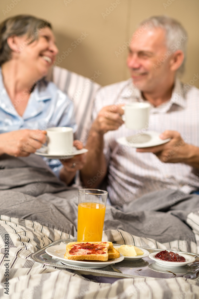 Mature couple enjoying breakfast at hotel room Mature couple enjoying breakfast at hotel room