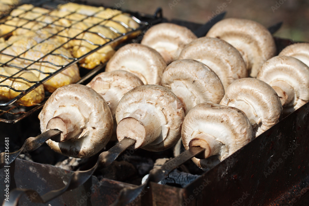 Cooking mushrooms (champignons Agaricus bisporus) on grill Cooking mushrooms (champignons Agaricus bisporus) on grill