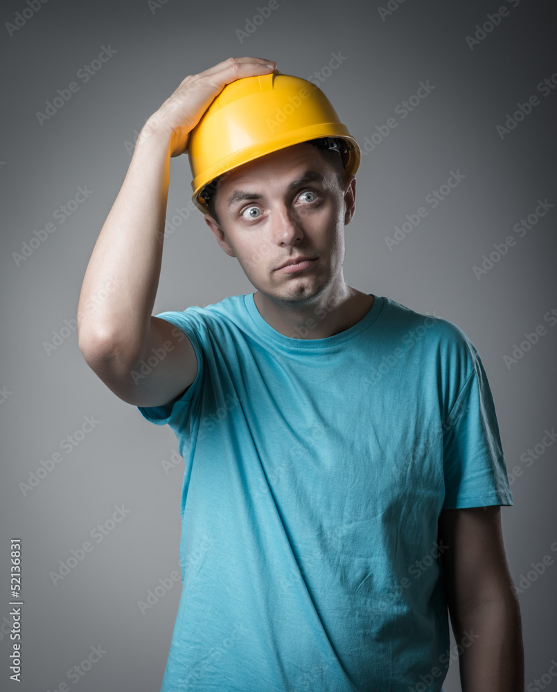 worker in helmet holding his head worker in helmet holding his head