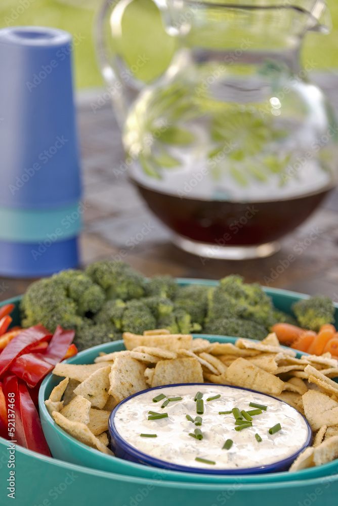 Dip with pita chips, vegetables and iced tea served outdoors Dip with pita chips, vegetables and iced tea served outdoors
