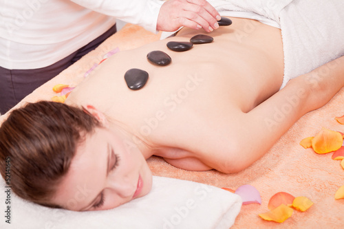 junge attraktve frau bekommt eine hot stone massage zur entspann