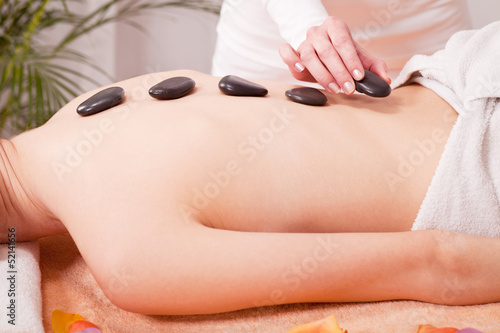 junge attraktve frau bekommt eine hot stone massage zur entspann