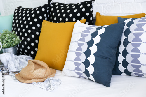 Colorful pillows on a sofa with white brick wall in background