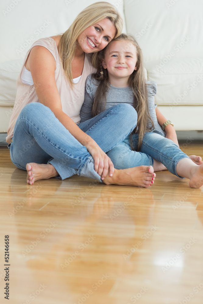 Mother and daughter sitting on the floor embracing Mother and daughter sitting on the floor embracing