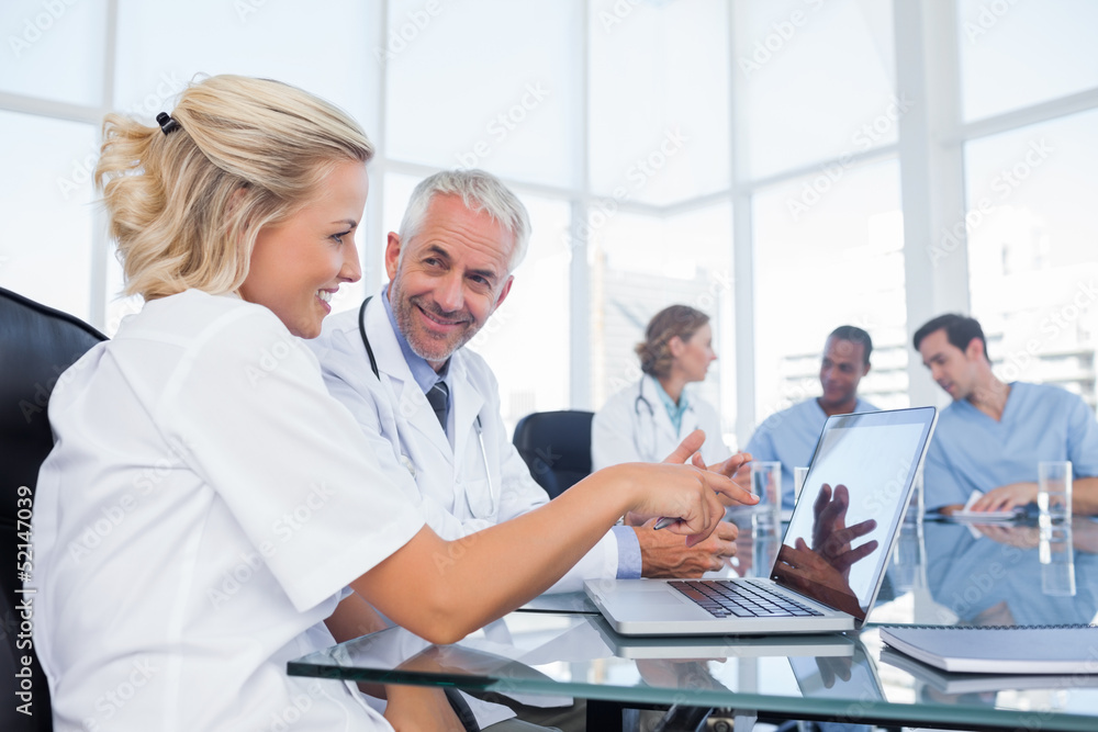 Two smiling doctors looking at a laptop Two smiling doctors looking at a laptop