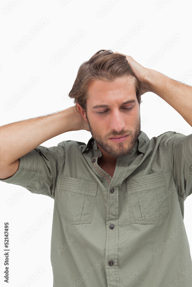 Stressed man looking down with hands on head Stressed man looking down with hands on head